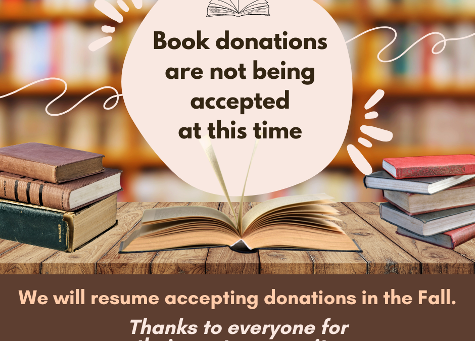 Image of books on table with full book shelves in background