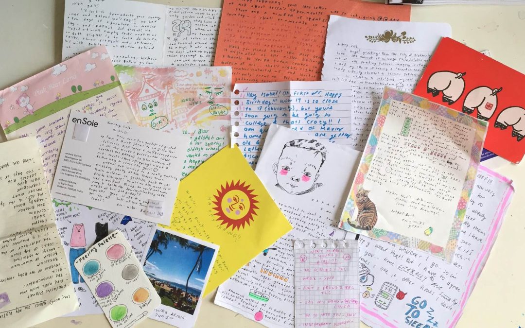 A collection of colorful handwritten letters and stationery scattered on a surface.