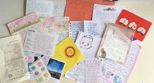 A collection of colorful handwritten letters and stationery scattered on a surface.